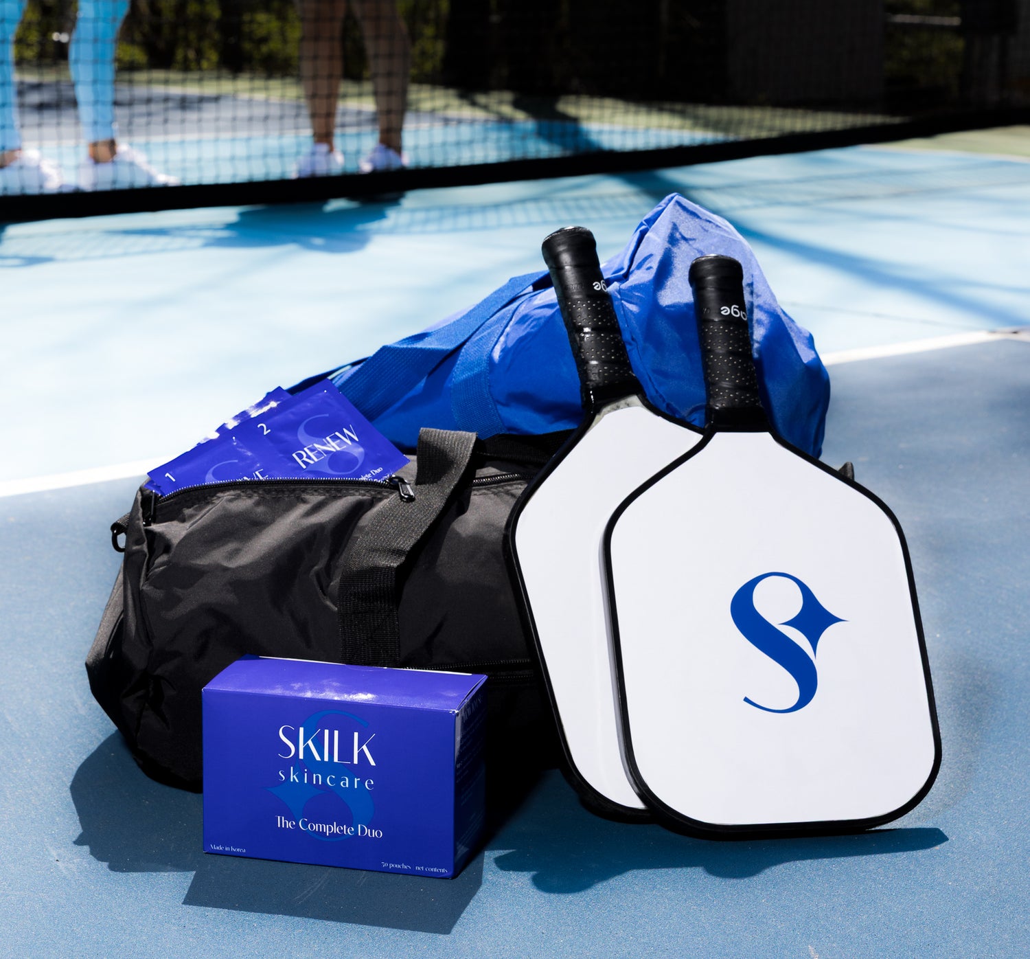 Skilk Skin wipes and skincare products on a pickleball court, designed for active and on-the-go lifestyles.